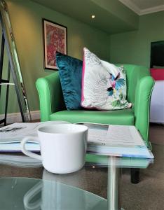 uma chávena de café sentada numa mesa de vidro ao lado de um sofá em Patricks Boathouse em Swansea