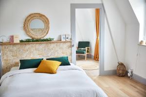 a bedroom with a bed with a yellow pillow on it at Demeure de Manneville - SPA - 1Km des plages de Cabourg in Dives-sur-Mer