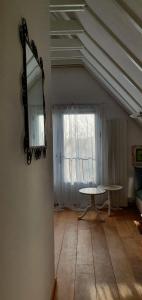 een kamer met een tafel en een spiegel aan een muur bij Sterrenhoeve in Castricum