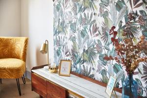 a living room with a chair and a table with a vase at Demeure de Manneville - SPA - 1Km des plages de Cabourg in Dives-sur-Mer
