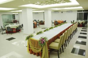 un lungo tavolo in una sala banchetti con tavoli e sedie di Coastal Peace a Cox's Bazar