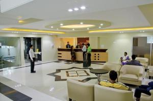 a lobby with people sitting in chairs and a man standing in a room at Coastal Peace in Cox's Bazar