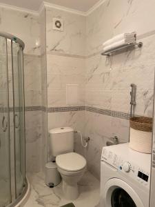a white bathroom with a toilet and a shower at Beach Residence Pomorie in Pomorie +31 photos
