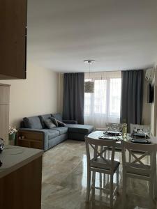 a living room with a couch and a table and chairs at Beach Residence Pomorie in Pomorie