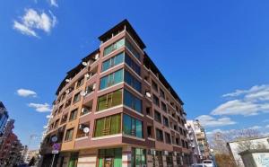 a tall building with many windows on a city street at Beach Residence Pomorie in Pomorie