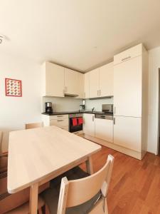 cocina con mesa de madera y armarios blancos en Near Lake Two Bedroom Fully Furnished Apartment, en Viena