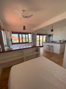 Navegantes Nascente في غاجيرو: غرفة نوم مع سرير ومطبخ مع مروحة سقف