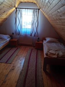 a attic bedroom with two beds and a window at Apartmány Božka in Terchová