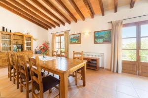 cocina y comedor con mesa de madera y sillas en Villa Cadell Petit, en Sa Pobla