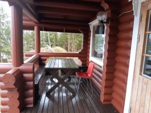a table and a chair on the porch of a cabin at Saimaa Raikala in Vuoriniemi