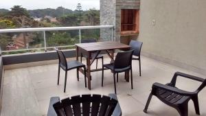 ein Holztisch und Stühle auf einem Balkon in der Unterkunft Libertador Norte Departamentos in Pinamar