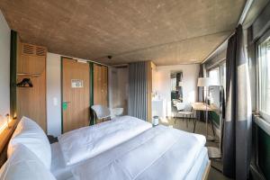 1 dormitorio con 2 camas blancas y escritorio en Centre Loewenberg, en Murten