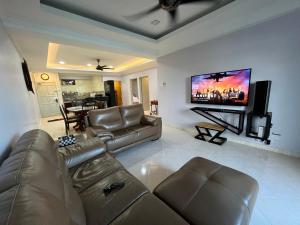a living room with a couch and a flat screen tv at EagleNest at Marina Cove Resort in Lumut