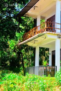 a balcony on the side of a house with trees at La Ciel Ella in Ella