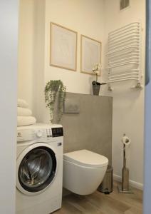 a bathroom with a washing machine and a toilet at Apartament 104/29 Sunset Resort Grzybowo in Grzybowo