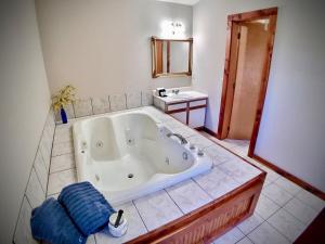 uma grande banheira na casa de banho com lavatório em Cedar Creek Cabins em Eureka Springs