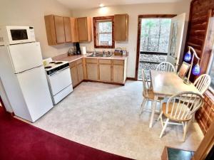 uma cozinha com um frigorífico branco e uma mesa com cadeiras em Cedar Creek Cabins em Eureka Springs
