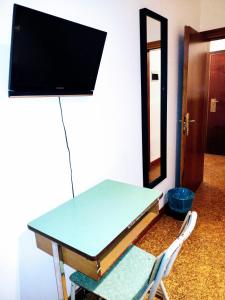einen Tisch mit einem TV darüber in der Unterkunft Affittacamere di Andrea Bertolino Anzola dell'Emilia in Anzola dell'Emilia