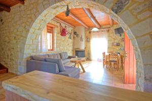 sala de estar con pared de piedra en Villa Vrisses by PosarelliVillas en Vryses