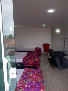 a room with beds and a table and a couch at Apartamento Duplex Mobiliado em São Pedro da Aldeia in São Pedro da Aldeia