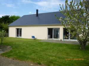 ein weißes Haus mit einer Bank im Hof in der Unterkunft Chambre chez l'habitant LGBT près de la plage naturiste de Granville in Bréville-sur-Mer