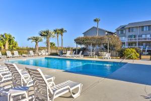 a swimming pool with white chairs and palm trees at Saint Helena Island Condo - Steps to Beach! in Oceanmarsh Subdivision
