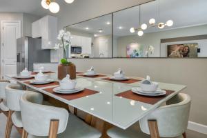 a dining room with a glass table and chairs at Formosa Valley by UNE Homes in Orlando