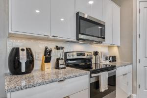 a kitchen with white cabinets and a stove top oven at Formosa Valley by UNE Homes in Orlando