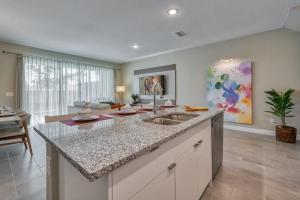 a kitchen with a sink and a living room at Formosa Valley by UNE Homes in Orlando