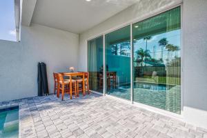 a patio with a table and chairs next to a pool at Formosa Valley by UNE Homes in Orlando