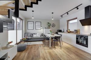 a kitchen and living room with a table and chairs at Przy Cegielni in Tylicz