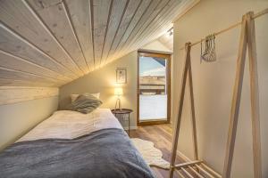 a bed in a room with a wooden ceiling at Przy Cegielni in Tylicz