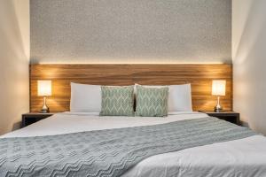 a bedroom with a large white bed with two lamps at Formosa Valley by UNE Homes in Orlando