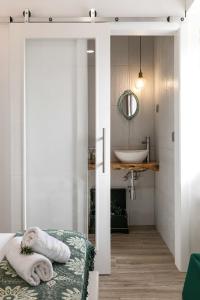 a bathroom with a bed and a sink and a mirror at Casa Trilhos da Serra in Alcobertas