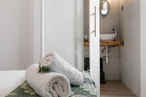 a bathroom with towels on a bed and a sink at Casa Trilhos da Serra in Alcobertas