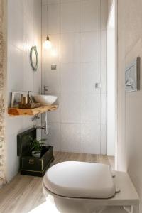 a white bathroom with a toilet and a sink at Casa Trilhos da Serra in Alcobertas