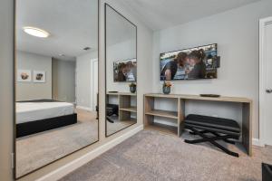 a bedroom with a bed and a desk with a mirror at Formosa Valley by UNE Homes in Orlando