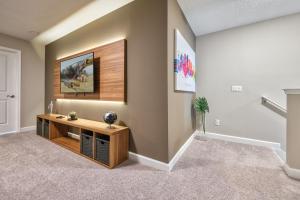 a living room with a tv and a table at Formosa Valley by UNE Homes in Orlando