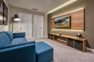 a living room with a blue couch and a tv at Formosa Valley by UNE Homes in Orlando