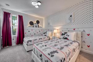 two beds in a bedroom with red curtains at Formosa Valley by UNE Homes in Orlando