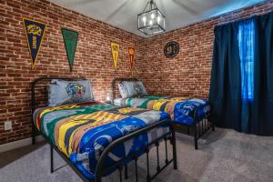two beds in a room with a brick wall at Formosa Valley by UNE Homes in Orlando
