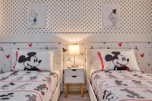 two beds in a bedroom with a mickey mouse room at Formosa Valley by UNE Homes in Orlando