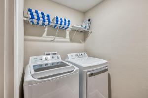 a small laundry room with a washer and dryer at Formosa Valley by UNE Homes in Orlando
