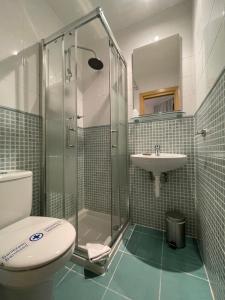 a bathroom with a shower and a toilet and a sink at Pensión Artea in San Sebastián