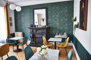 a restaurant with green walls and tables and chairs at Demeure de Manneville - SPA - 1Km des plages de Cabourg in Dives-sur-Mer