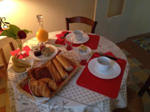 a table with a breakfast of bread and croissants at Suite Sainte Anne in Beaumont-sur-Sarthe +17 photos