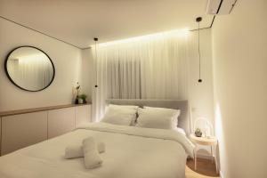 ein weißes Schlafzimmer mit einem großen Bett und einem Spiegel in der Unterkunft Sunlight-Luxury and sea view apartment in Eilat