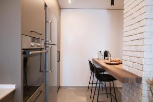 a kitchen with a wooden table and a brick wall at דירת 3 חדרי שינה מרווחת עם נוף לים in Eilat