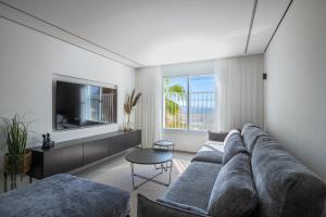 a living room with a couch and a tv at דירת 3 חדרי שינה מרווחת עם נוף לים in Eilat