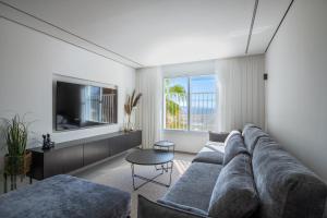 a living room with a couch and a tv at Sunlight-Luxury and sea view apartment in Eilat